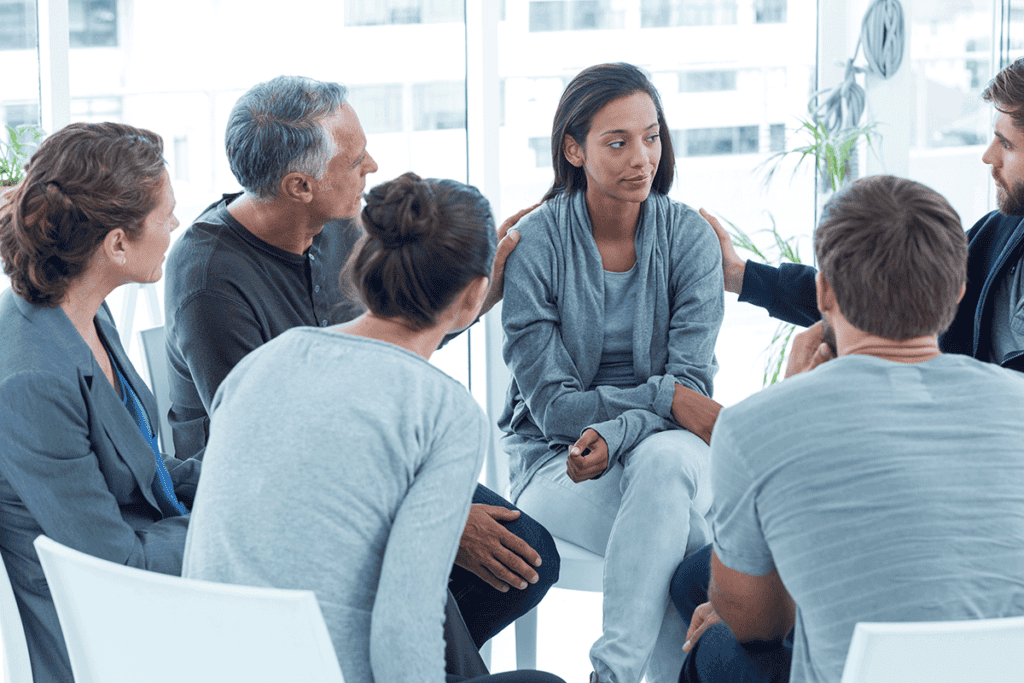 People sitting in a circle and talking about how effective group therapy is for addiction treatment
