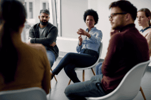 People sitting in a circle and talking about the advantages of group therapy