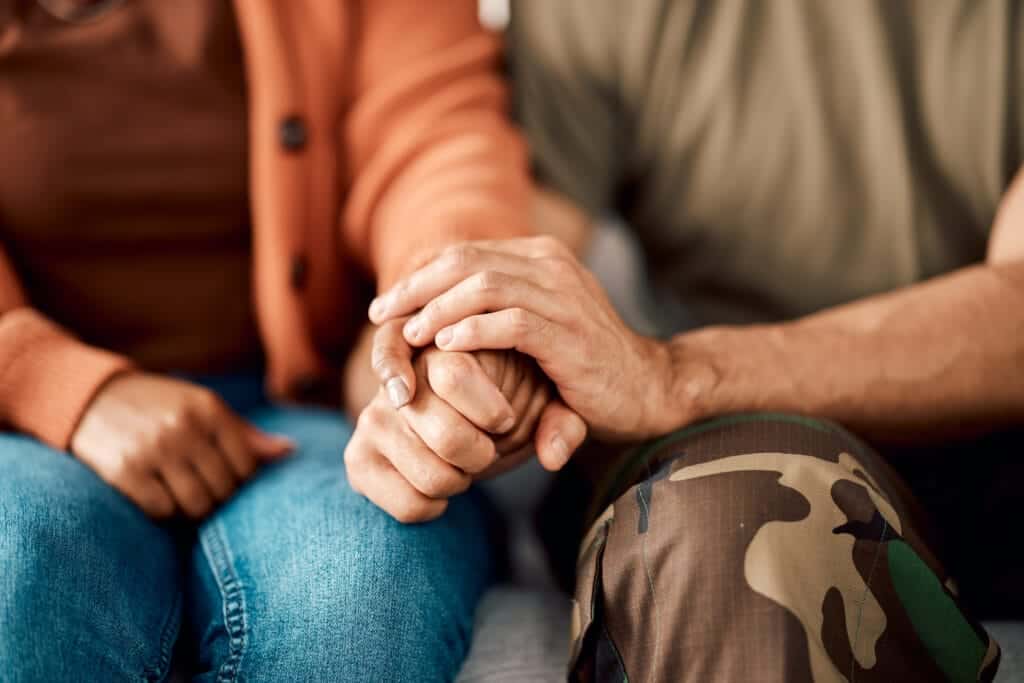Hands of two people talking about PTSD and substance abuse signs